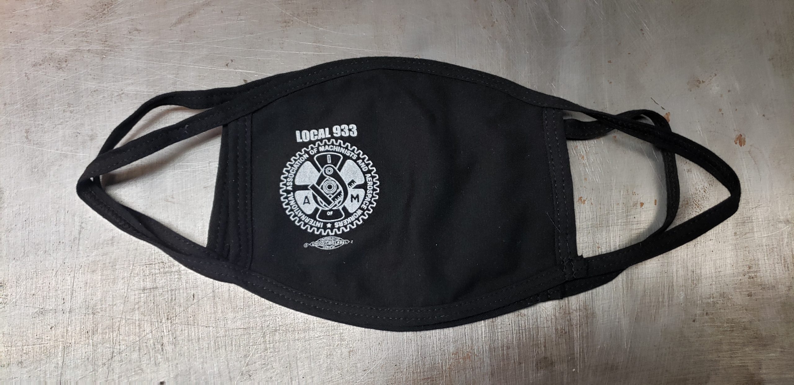 Black cotton face mask with union screen printed one color design featuring the logo of the International Association of Machinists and Aerospace Workers with the text, "LOCAL 933" above it